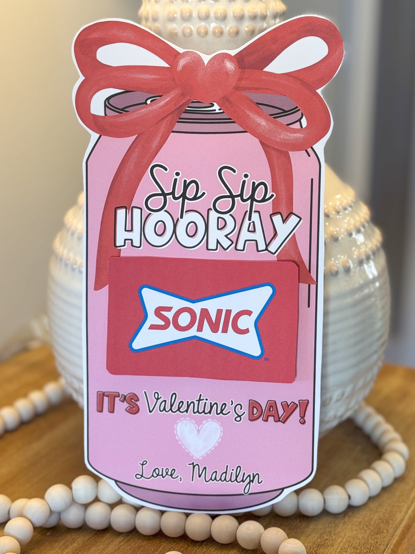 Valentine's Day card with pink bottle design and 'Sip Sip Hooray' text, featuring Sonic the Hedgehog logo.