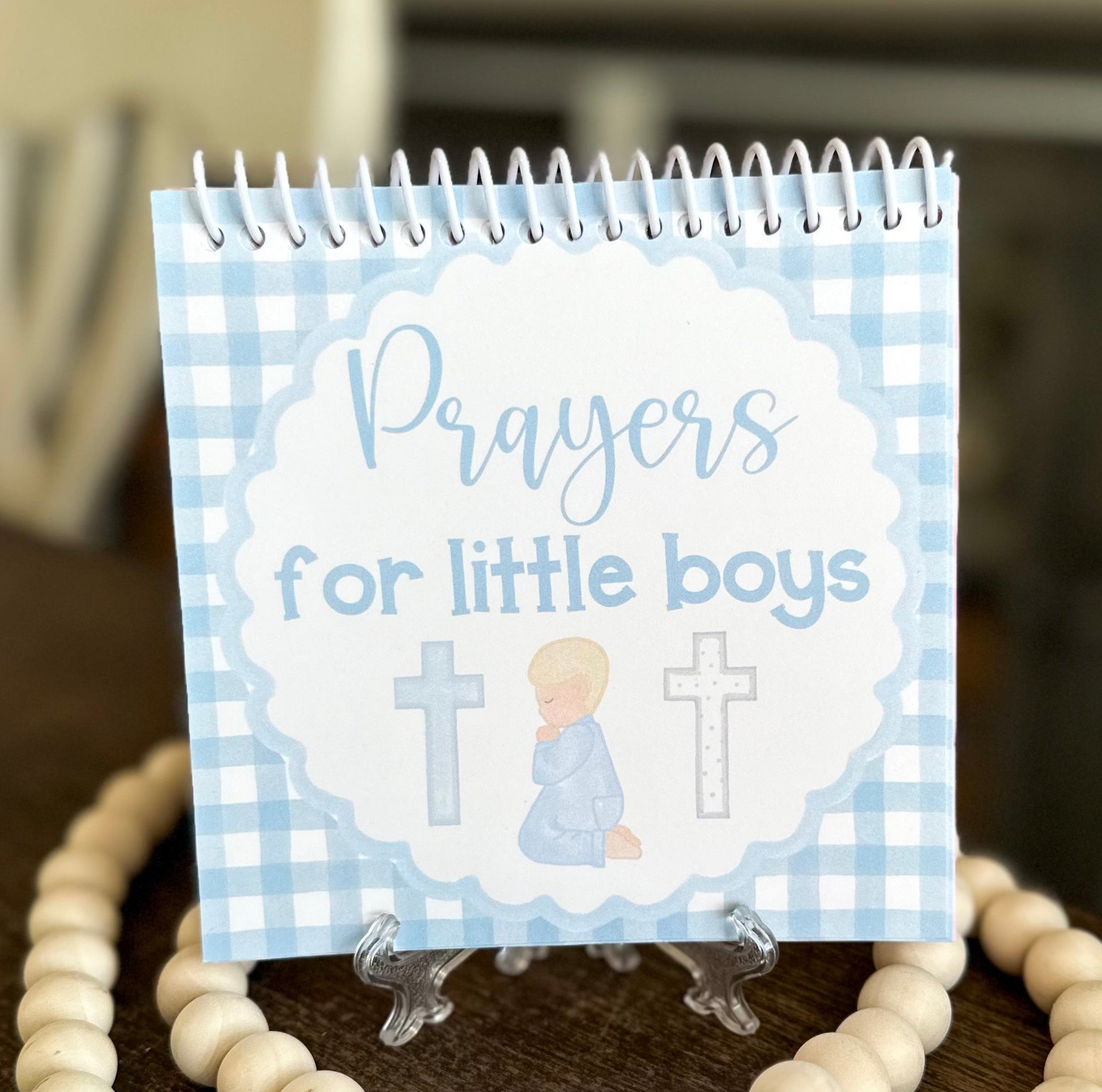 Notebook titled 'Prayers for little boys' with a blue checkered design on a wooden surface.