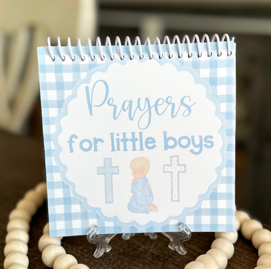 Notebook titled 'Prayers for little boys' with a blue checkered design on a wooden surface.