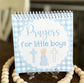 Notebook titled 'Prayers for little boys' with a blue checkered design on a wooden surface.